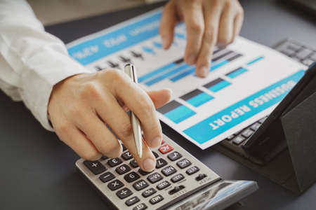 Businessman doing finances and calculate about cost to investment , business Financing Accounting Banking Concept, tax systemの写真素材