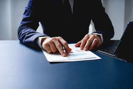 Businessman doing finances and calculate about cost to investment , business Financing Accounting Banking Concept, tax systemの写真素材