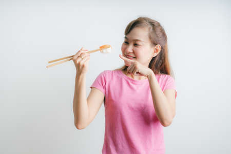 Close-up. young lady eating sushi rollの写真素材