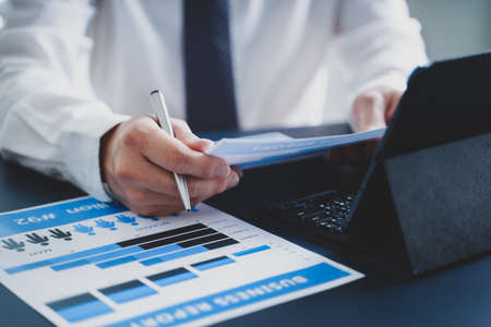 Businessman doing finances and calculate about cost to investment , business Financing Accounting Banking Concept, tax systemの写真素材
