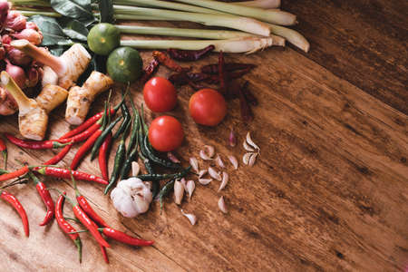 Various fresh vegetables and spices on wooden tableの写真素材