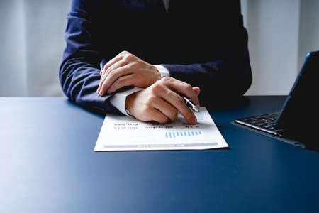 Businessman doing finances and calculate about cost to investment , business Financing Accounting Banking Concept, tax systemの写真素材