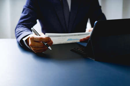Businessman doing finances and calculate about cost to investment , business Financing Accounting Banking Concept, tax systemの写真素材