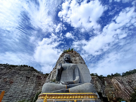 The landscape of monks carved on the cliff Wat Khao Tiam in Thailand, beautiful with clear sky, beautiful trees on the cliff, religious cultural attraction.の写真素材