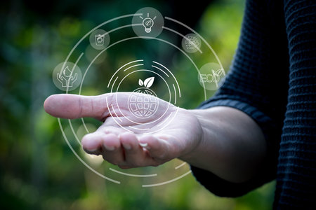 Woman's hand holding eco icon on nature background. Ecology concept. protection earth concept.