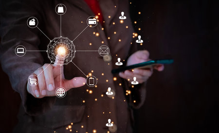 Businessman hand holding smartphone with social network icons on dark background. Business global internet connection application technology and digital marketing.の写真素材