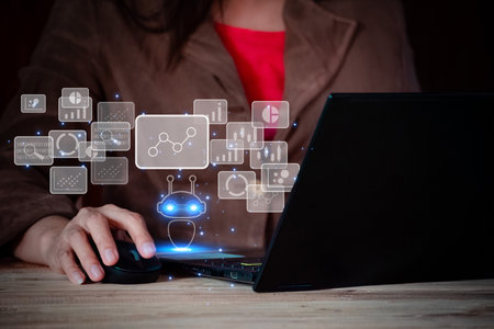 Businesswoman working on laptop at desk with high tech icons and symbols, robot application and global connection, conversation AI, business in online network.の写真素材