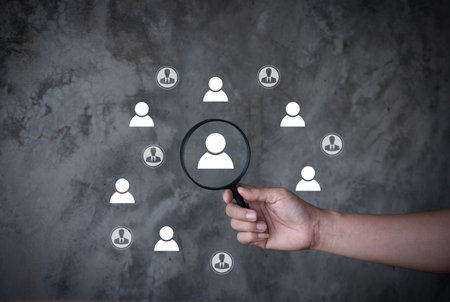 HRM or Human Resource Management, Magnifier glass focus to manager icon which is among staff icons for human development recruitment leadership and customer target group concept.の写真素材