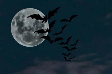 Halloween background with bats flying in the night sky and full moon