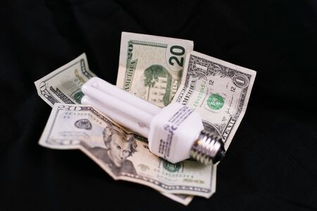 energy saving lamp on piles of moneyの写真素材