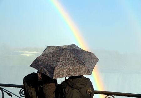 A couple with an umbrella and a rainbowの写真素材