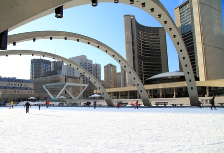TORONTO - MARCH 16: Skating on Nathan Phillips Square outdoor rink in Toronto on March 16, 2013. In Winter, the City Hall pool is frozen into a popular outdoor skating rink.のeditorial素材