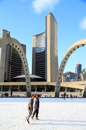 TORONTO - MARCH 16: Skating on Nathan Phillips Square outdoor rink in Toronto on March 16, 2013. In Winter, the City Hall pool is frozen into a popular outdoor skating rink.のeditorial素材