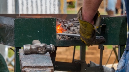Detailed shot of metal being worked at a blacksmithing forge