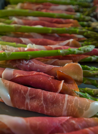 Fresh wrapped ham on delicious asparagusの写真素材