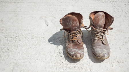 Old brown work boots covered in concreteの写真素材