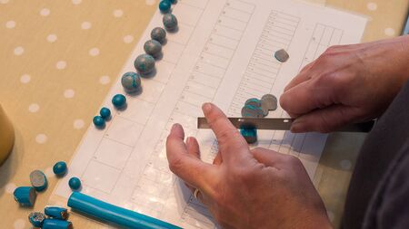 female hand making jewlery from polymer clay. Hobby, handicraft