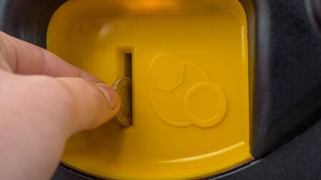 Close-up Hand putting a coin self service machineの写真素材