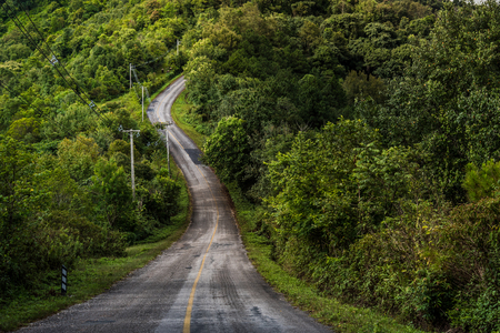 Mountain slope tramac road in countryside scenery. Dangerous mountain slope in rural valley background.の写真素材