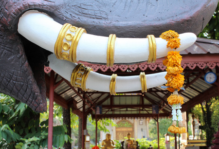 Flower hanging on tusk of elephant statue in Wat Lamchang, Chiangmai, Thailand.の写真素材