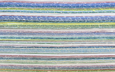 Stack of colorful used paper texture background.