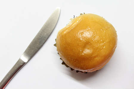 A small bread with a  knife on white background.の写真素材