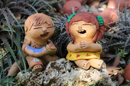 Smiling clay doll girls in the garden.の写真素材