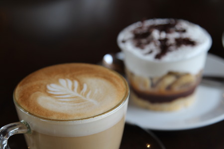 Hot cappuccino in glass cup on wooden table.の写真素材