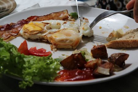 American breakfast with fried egg , bacon and fried potato on white plate.の写真素材