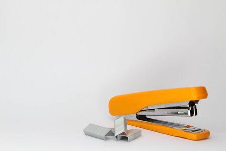 Closeup of orange stapler and staple. Focus at staple.の写真素材