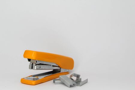 Closeup of orange stapler and staple.の写真素材