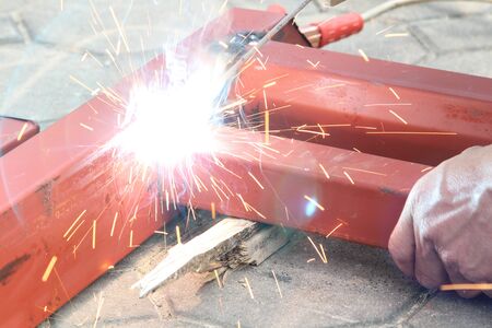 Welder work welding metal with electric welder.