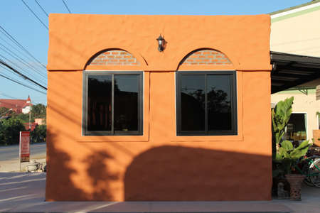 Black aluminium window on saturate orange wall house.の写真素材