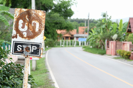 Old rusty stop sign on blur traffic road.の写真素材