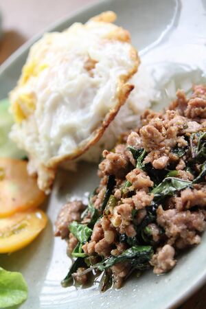 Stir-fried pork with basil leaves and fried egg on rice.の写真素材