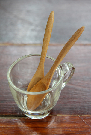 Wooden spoon in a clear glass coffee cup on the table.の写真素材