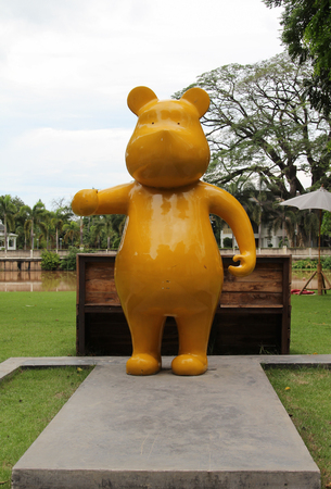 Yellow big bear statue standing on concrete floor.の写真素材
