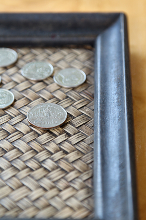 Thai coins on wooden tray.の写真素材