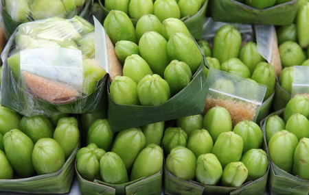 Green Bilimbi or Ta Ling Pling fruit sour taste dipping with salt pepper on banana leaf ready for sale.の写真素材