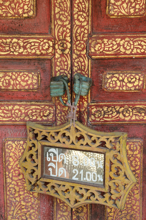 Wooden working time sign hanging on wooden door.の写真素材