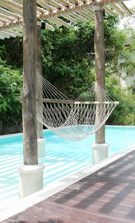 White hammock hanging over the pool in the resort.の写真素材