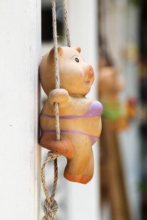 Closeup view of clay pig doll hanging on the wall.の写真素材