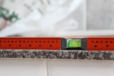 Close-up of orange spirit level on marble sheet.の写真素材
