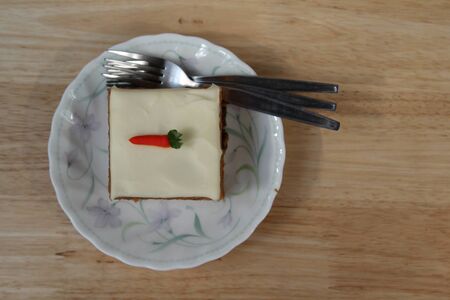 Piece of carrot cake with cream cheese on white plate.の写真素材