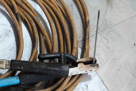 Welding electrode holder with electrode wire on the floor.