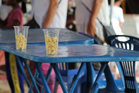 Pop corn in plastic clear glass on steel table.の写真素材