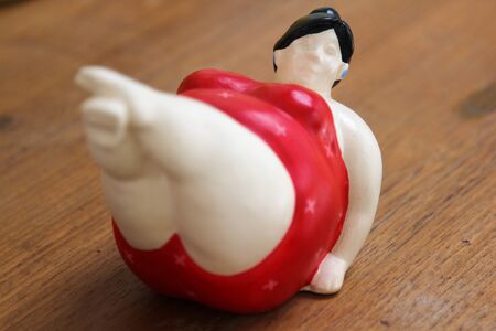 Clay doll fat woman on wooden table.の写真素材