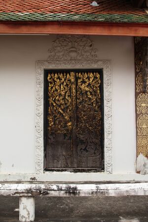 Old wooden church door of the Thai temple.の写真素材