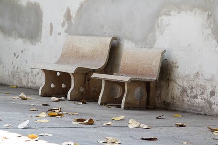 Old concrete bench next to the concrete wall.