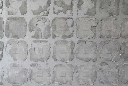 The dark grey old concrete wall texture after removed the tiles.